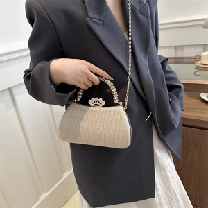 Detail of champagne gold clutch with pearl handle and crown clasp in high texture