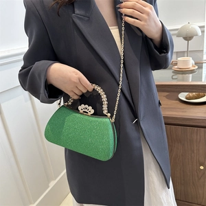 Elegant green glitter evening bag with rhinestone handle and crown clasp detail