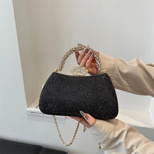Detail of black glitter evening clutch with rhinestone handle and crown-shaped clasp
