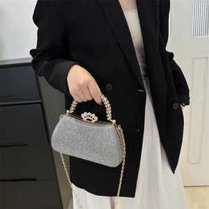 Silver sequin clutch bag with crystal handle and crown clasp shown on black blazer