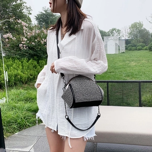 Detail of trendy black crossbody bag featuring dense silver rhinestone embellishments