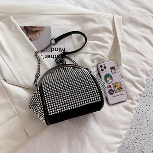 Detail of black crossbody bag with silver rhinestones and retro metal ball clasp closure