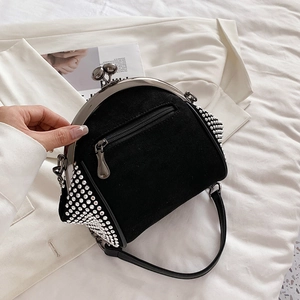 Macro shot of black suede frame bag featuring sparkling rhinestones and metal kiss-lock