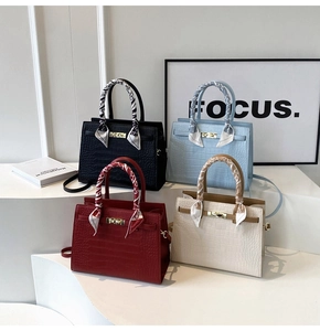 Detail view of four textured crocodile pattern handbags with colorful silk scarf handles