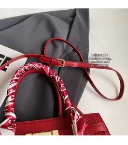 Detail of red crocodile pattern handbag with heart scarf wrap and adjustable strap