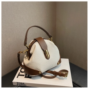 White pebbled leather shell bag with dark brown handles and elegant gold buckle closure