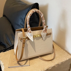 Chic beige crocodile embossed handbag with gold lock and silk scarf handle accent