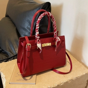 Elegant red crocodile texture handbag with silk scarf handle and adjustable strap