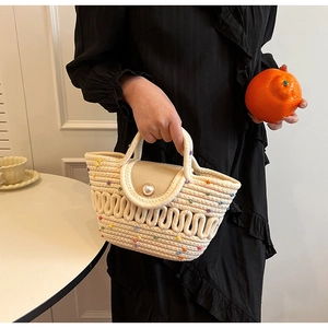 Détail du sac bandoulière tissé avec motifs de vagues colorées et fermoir perle