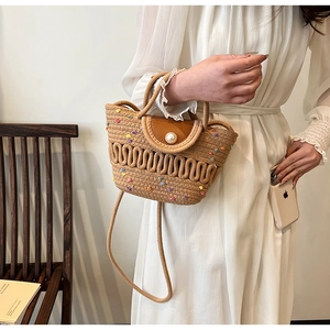 Détail du sac en paille tressée avec boucle perle, rabat en cuir et points colorés