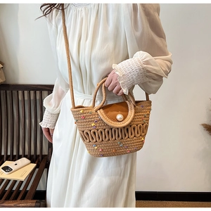 Sac bandoulière en paille avec pompons colorés et fermoir perle de détail