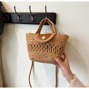 Vue détaillée du sac tissé kaki avec broderies fleurs et bouton perle élégant