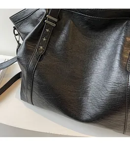 Détail du sac cabas noir en similicuir grainé avec des clous étoilés en métal