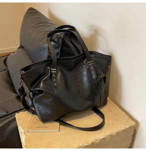 Détail du grand sac cabas en cuir PU noir avec rivets en étoile et bandoulière réglable