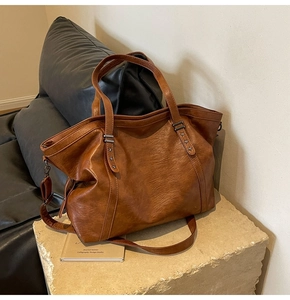 Détail du sac cabas vintage marron en cuir avec rivets étoiles sur socle en pierre