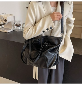 Détail d'un sac cabas noir en similicuir souple avec bandoulière réglable et texture