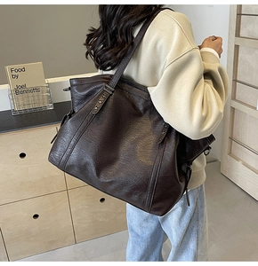 Gros plan sur un sac cabas en cuir marron foncé avec texture vintage et fine bandoulière