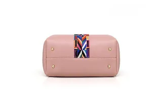 Vue détaillée du fond du sac en cuir rose avec sangle ethnique et rivets dorés de protection