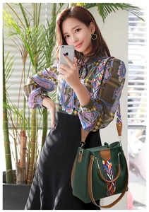 Détail du sac à main en cuir vert avec bandoulière à motifs géométriques ethniques