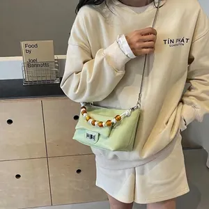 Mint green beaded handle shoulder bag with silver chain strap shown on model