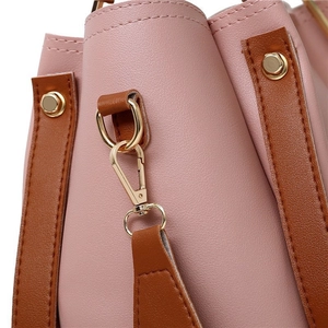 Détails du sac à main rose et marron avec ferrures dorées de qualité et coutures précises
