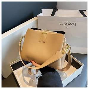 Detail of beige lychee leather bucket bag with inner pouch and gold hardware