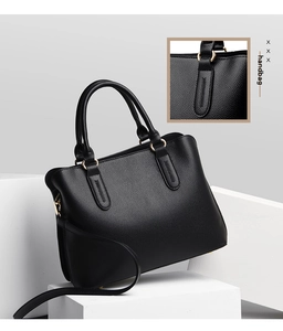 Detail of lychee textured leather tote with gold hardware and reinforced handles