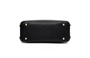 Close-up of black lychee textured tote bag bottom with four protective gold metal feet