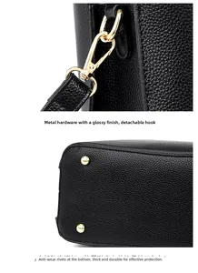 Detail of golden snap hooks and protective bottom rivets on black lychee leather tote