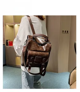 Brown vintage leather backpack with large front flap and buckles on a female model
