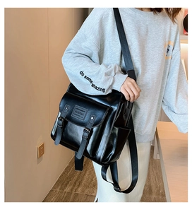 Detail of high-quality black PU leather backpack with decorative metal buckle straps