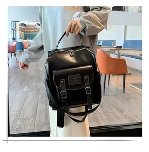Detail of high-gloss black leather backpack with dual zippers and adjustable shoulder straps