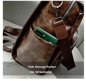 Detail shot of vintage leather sling bag with a functional side pocket for smartphones