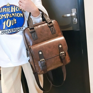 Close-up of vintage brown PU leather handbag showing pebbled texture and metal buckle detail