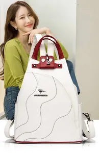 Detail of white lychee leather backpack showing red handle and wave stitch texture
