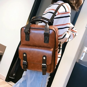 Detail of vintage brown PU leather backpack with magnetic flap and metal buckle accents