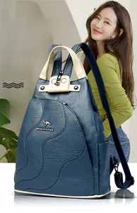 Detail of navy blue leather backpack featuring beige handles and kangaroo logo emblem