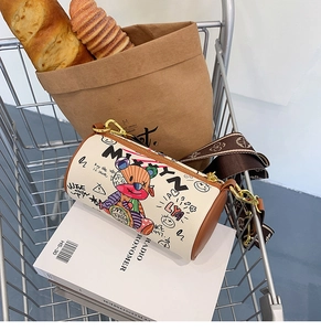 Détail du sac cylindrique blanc avec graffiti d'ours et large bandoulière jacquard