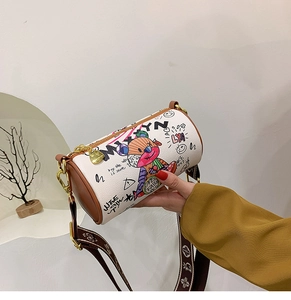 Détail du sac cylindrique blanc avec graffiti d'ours et garniture en cuir marron