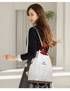Detail of white lychee leather backpack with red trim and wavy stitching accents