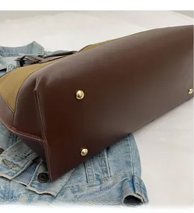 Detailed view of canvas tote bag bottom with protective gold metal feet studs