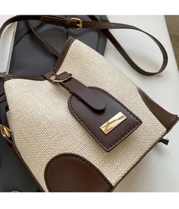 Detail of woven fabric texture and dark brown leather trim on the mini bucket crossbody bag