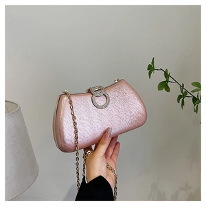 Detail of pink sequin evening clutch featuring a double-ring rhinestone buckle and gold chain