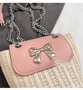 Gros plan sur la texture tissée beige avec rabat en cuir rose et boucle nœud argentée