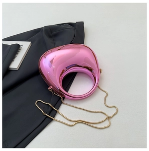 Close-up of pink metallic teardrop bag with hollow round handle and gold chain strap