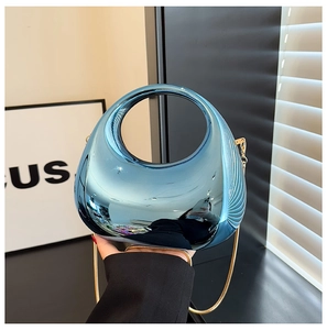 Detail of blue mirror finish oval bag with golden snake chain and integrated handle