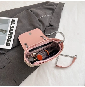 Vue intérieure d'un sac en paille à nœud rose avec rouge à lèvres et produits cosmétiques
