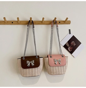 Détail de sacs en paille tressée avec rabats color-block et fermoirs nœud argentés