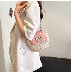 Détail du fermoir nœud rose et texture tissée sur un sac bandoulière tendance