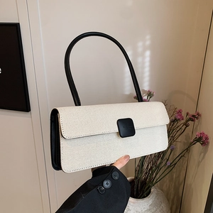 Detail einer minimalistischen weißen Web-Handtasche mit schwarzem Griff und Schnalle